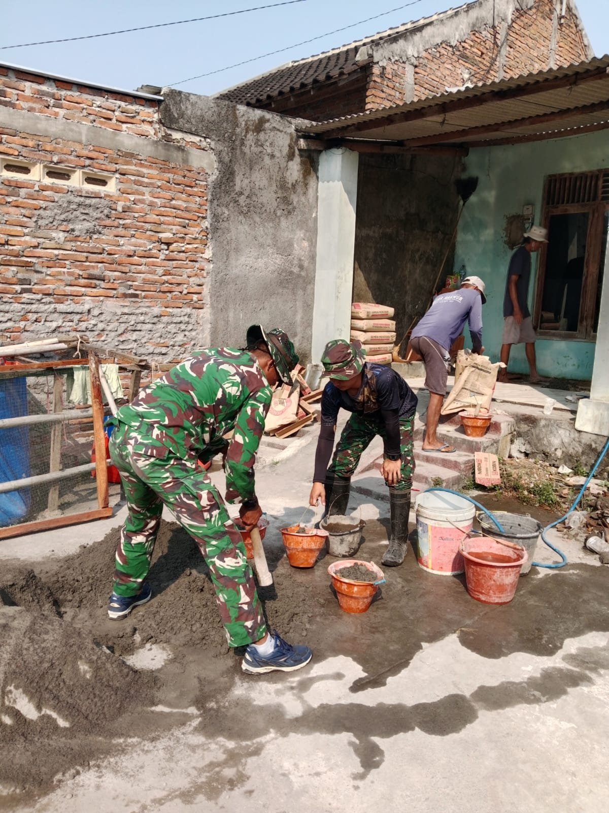 Sertu Yusman dan Warga Rampungkan Pemasangan Keramik di Sukoharjo
