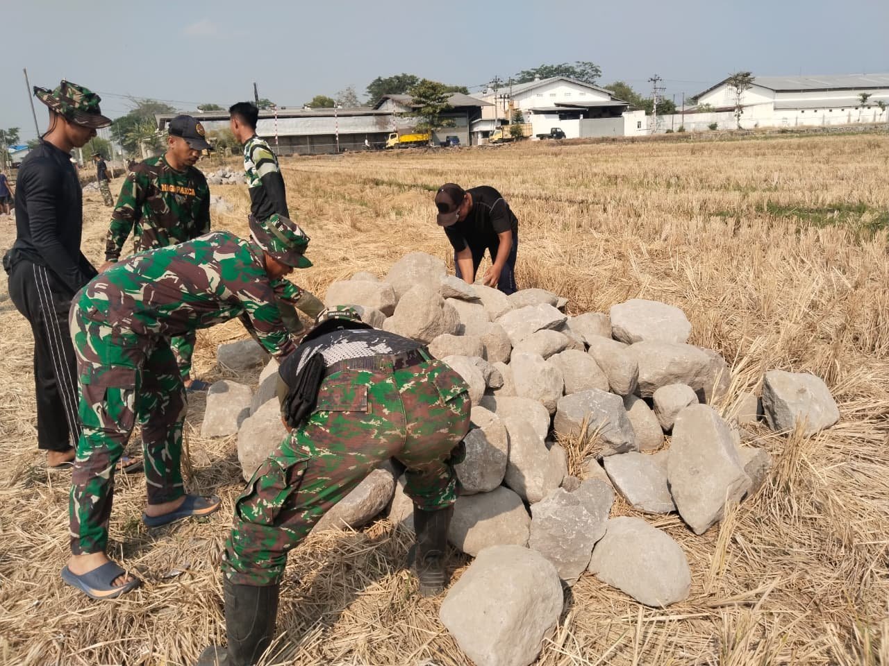 Warga dan Prajurit Satgas TMMD Angkut Batu untuk Talud di Kawasan Pertanian Parangjoro