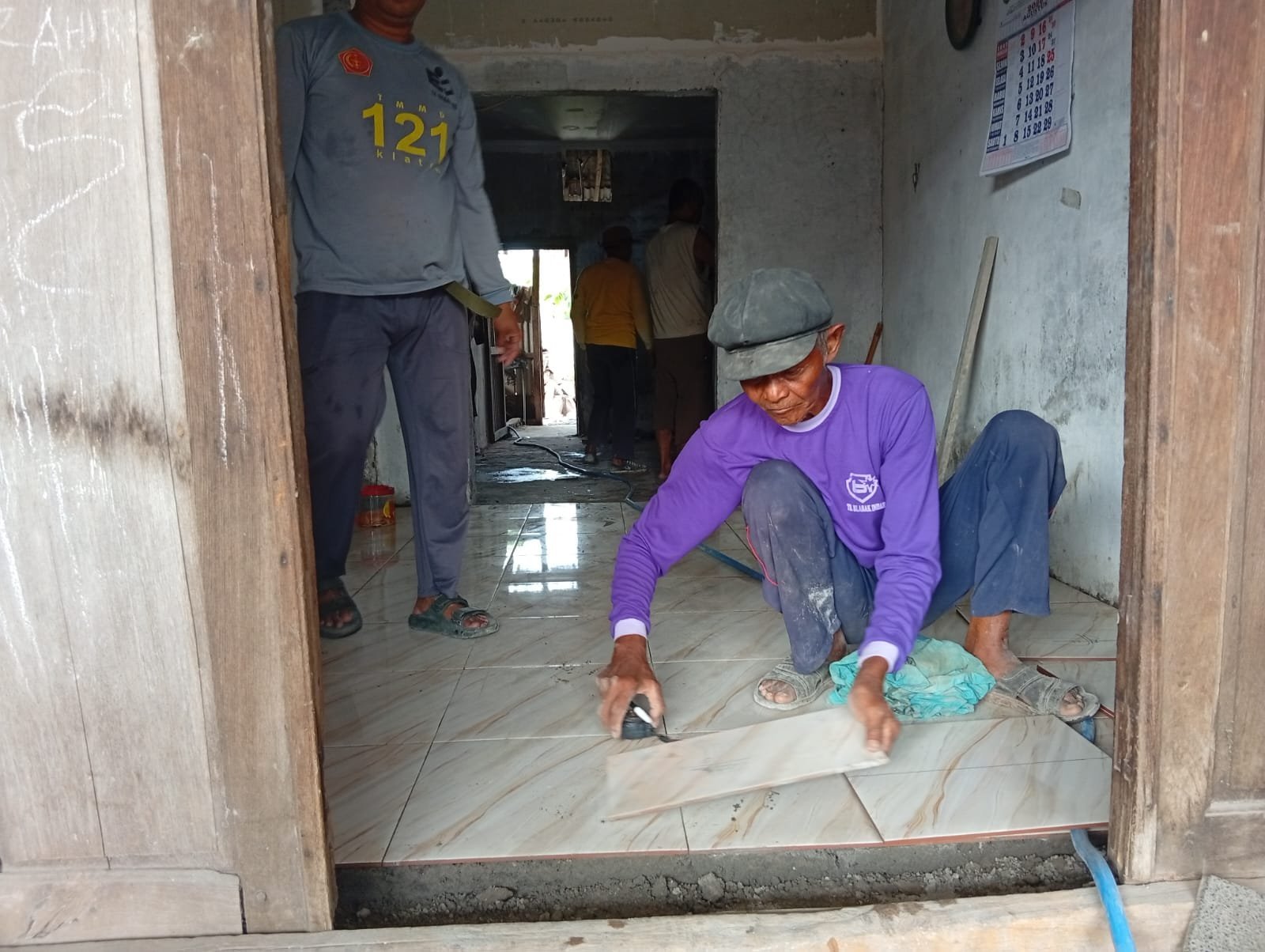 TMMD 129 dan Warga Perbaiki Lantai Rumah Subani di Parangjoro